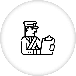 A man in uniform holding papers sitting on the ground.