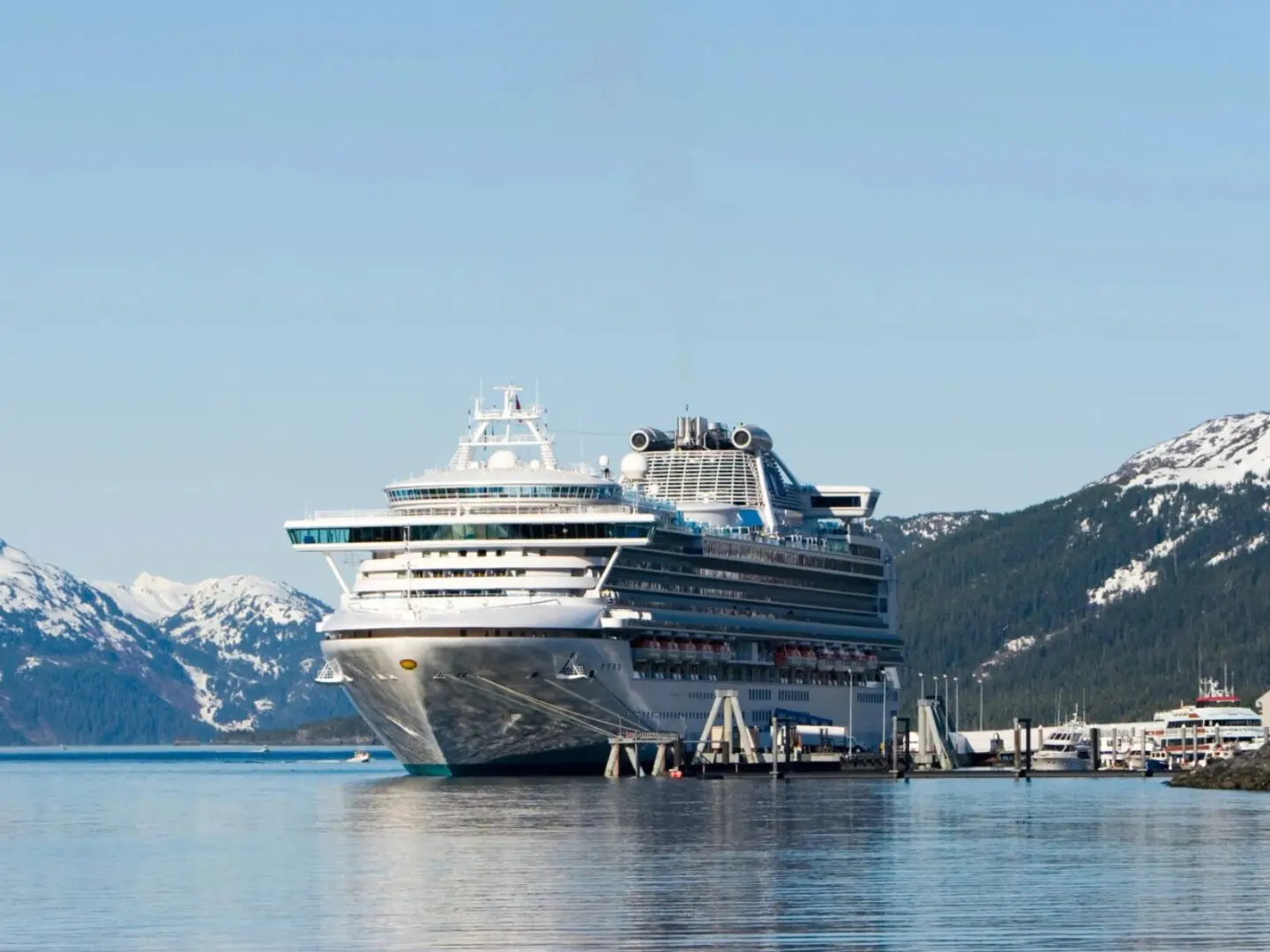 fm=f_116773 (1) A cruise ship docked in the water near mountains.
